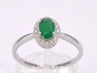 Witgouden entourage ring met diamanten en smaragd