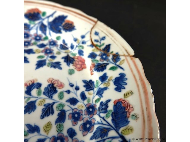 Antiek chinese porseleinen bord uit de 18e-eeuwse kangxi-periode. gedecoreerd met blauw-wit bloemmotieven en een gegolfde rand. - afbeelding 4 van  5