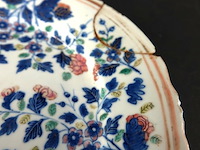 Antiek chinese porseleinen bord uit de 18e-eeuwse kangxi-periode. gedecoreerd met blauw-wit bloemmotieven en een gegolfde rand. - afbeelding 4 van  5