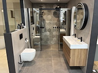 Badkamer showroom opstelling met badmeubel, spiegelkast, douche, designradiator en wandcloset