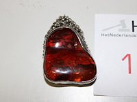Barnsteen in zilveren hanger. afmeting 4 x 6 cm.