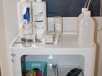 Behandelwagen met twee vakken, gevuld met diverse producten en accessoires t.b.v. huidverzorging. - afbeelding 2 van  6