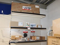 Berg accessoires waaronder side skirts, mudguards en soundbox op drie schappen.