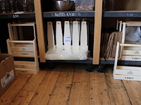 Bierkratjes en tasjes met diverse opdruk op drie schappen. - afbeelding 1 van  4