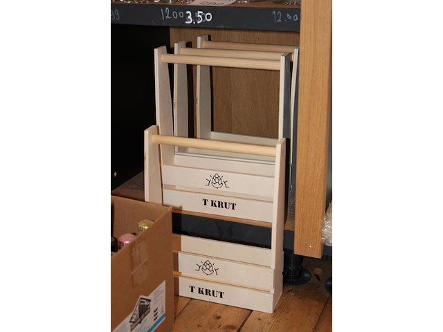 Bierkratjes en tasjes met diverse opdruk op drie schappen. - afbeelding 2 van  4