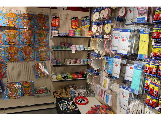 Cadeautjes in diverse soorten en maten op wandschap en in klapkrat w.o. blikken, sokken, spaarpotten, geurk... - afbeelding 1 van  2