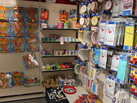 Cadeautjes in diverse soorten en maten op wandschap en in klapkrat w.o. blikken, sokken, spaarpotten, geurk... - afbeelding 1 van  2