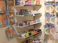 Cadeautjes in diverse soorten en maten op wandschap en in klapkrat w.o. blikken, sokken, spaarpotten, geurk... - afbeelding 2 van  2