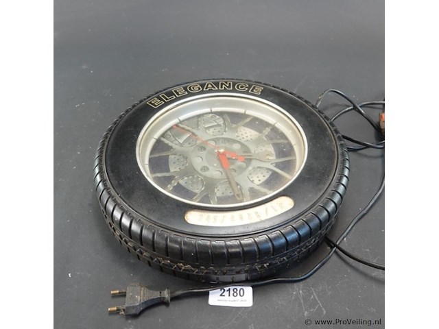 Decoratieve wandklok in de vorm van een autoband met velg, van het merk elegance - afbeelding 1 van  5