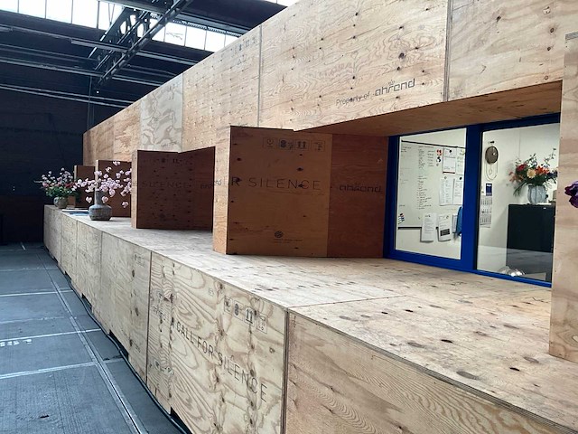 Decoratiewand circa 16 meter bestaande uit transportkisten en underlaymentplaten - afbeelding 1 van  3