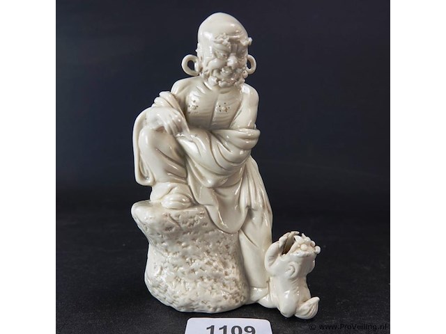 Dehua figurine bezig met dressuur fu dog zittend op een rots, blanc de chine 19/20e eeuw met blindmerk - afbeelding 1 van  5