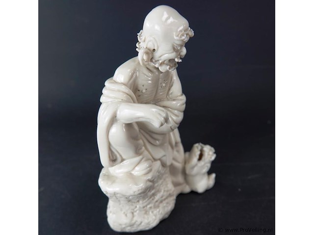 Dehua figurine bezig met dressuur fu dog zittend op een rots, blanc de chine 19/20e eeuw met blindmerk - afbeelding 2 van  5