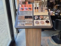Delilah cosmetics make-up display op houten zuil