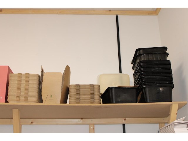 Disposables op twee schappen en onderschap werkbank w.o. bakjes, tasjes, lepels en dozen. - afbeelding 2 van  7