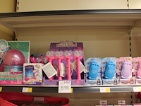 Diverse speelgoedproducten w.o. princess mobile phones, heart wand etc. in en op 2 schappen.