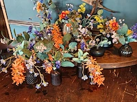Diverse vaasjes met kunststof bloemen
