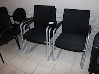 Drie stapelbare lederstoelen zwart gestoffeerd.