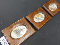Drie verticale, kleine wanddecoraties met houten lijsten en ovale geborduurde of kruissteekvoorstellingen van vogels en een windmolen - afbeelding 2 van  5