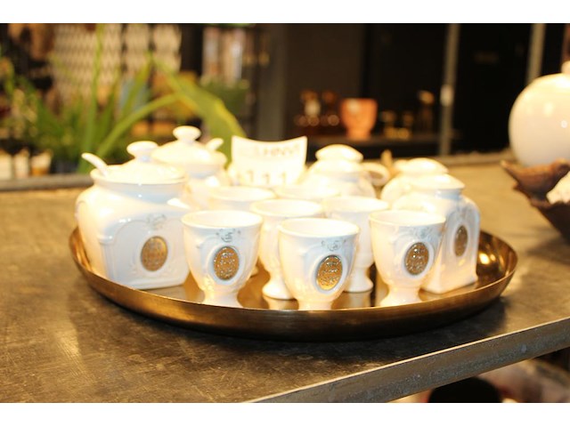 Eierdopjes, peper- en zoutstellen en suiker- en roomstellen op dienblad. - afbeelding 1 van  2