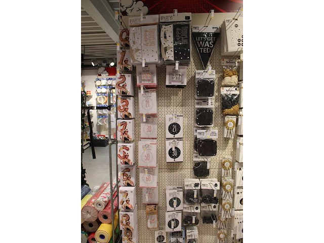 Feestartikelen/accessoires aan vier en halve wandschap w.o. ballonnen, slingers, kaarsen, buttons en tasjes. - afbeelding 2 van  11