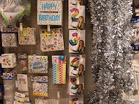 Feestartikelen/accessoires aan vier en halve wandschap w.o. ballonnen, slingers, kaarsen, buttons en tasjes. - afbeelding 5 van  11