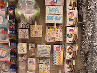 Feestartikelen/accessoires aan vier en halve wandschap w.o. ballonnen, slingers, kaarsen, buttons en tasjes. - afbeelding 6 van  11