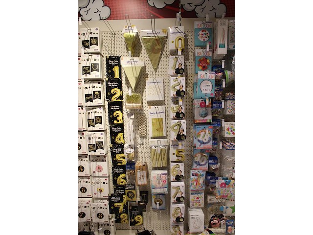 Feestartikelen/accessoires aan vier en halve wandschap w.o. ballonnen, slingers, kaarsen, buttons en tasjes. - afbeelding 9 van  11