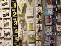 Feestartikelen/accessoires aan vier en halve wandschap w.o. ballonnen, slingers, kaarsen, buttons en tasjes. - afbeelding 9 van  11