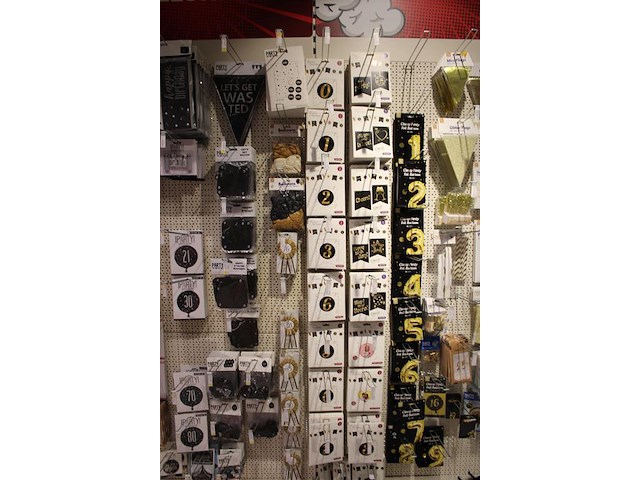 Feestartikelen/accessoires aan vier en halve wandschap w.o. ballonnen, slingers, kaarsen, buttons en tasjes. - afbeelding 11 van  11
