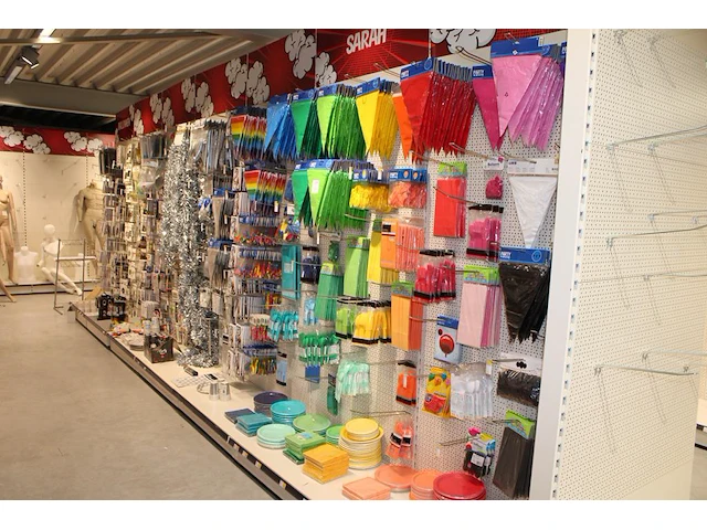 Feestartikelen/accessoires aan vier en halve wandschap w.o. ballonnen, slingers, kaarsen, buttons en tasjes... - afbeelding 1 van  8