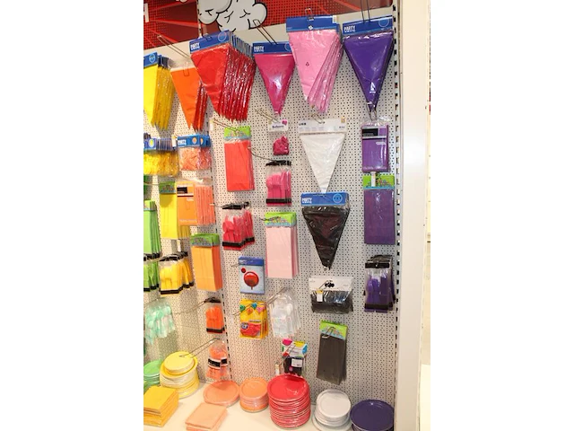 Feestartikelen/accessoires aan vier en halve wandschap w.o. ballonnen, slingers, kaarsen, buttons en tasjes... - afbeelding 3 van  8