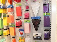 Feestartikelen/accessoires aan vier en halve wandschap w.o. ballonnen, slingers, kaarsen, buttons en tasjes... - afbeelding 3 van  8