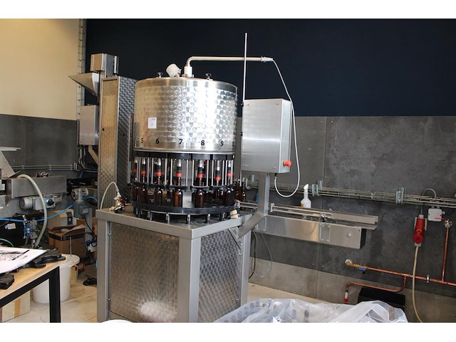 Flessenafvulmachine ktm troxler tva bestaande 16 koppige vulunit, co2 niveauregeling en kroonkurkapparaat. ... onderdeel van combinatiekavel complete mini brouwerijopstelling bestaande uit brouwhuis, 8 gistingstanks (deels gevuld), bottellijn, pompen, warmtewisselaar, natte lijn etiketteermachine en chiller - afbeelding 1 van  8