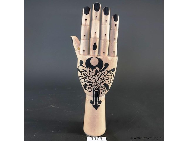 Gearticuleerde/gelede houten hand met een decoratieve, met de hand aangebrachte tatoeage-achtige illustratie van een chrysant op de handpalm en zwarte nagels - afbeelding 1 van  5