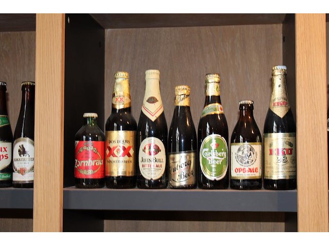 Grote hoeveelheid oude bierflessen en blikken op schap, in drie kast vakken en drie dozen. circa 150 stuks. - afbeelding 2 van  12