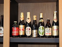 Grote hoeveelheid oude bierflessen en blikken op schap, in drie kast vakken en drie dozen. circa 150 stuks. - afbeelding 2 van  12