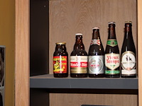 Grote hoeveelheid oude bierflessen en blikken op schap, in drie kast vakken en drie dozen. circa 150 stuks. - afbeelding 3 van  12