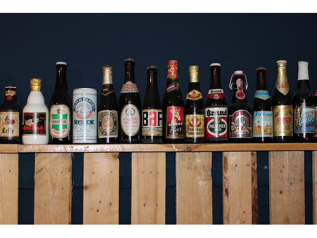 Grote hoeveelheid oude bierflessen en blikken op schap, in drie kast vakken en drie dozen. circa 150 stuks. - afbeelding 9 van  12