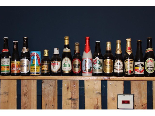 Grote hoeveelheid oude bierflessen en blikken op schap, in drie kast vakken en drie dozen. circa 150 stuks. - afbeelding 10 van  12