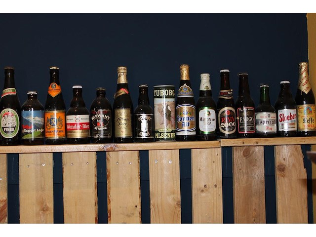 Grote hoeveelheid oude bierflessen en blikken op schap, in drie kast vakken en drie dozen. circa 150 stuks. - afbeelding 11 van  12