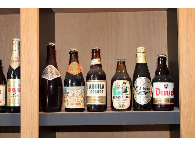 Grote hoeveelheid oude bierflessen en blikken op schap, in drie kast vakken en drie dozen. circa 150 stuks. - afbeelding 12 van  12