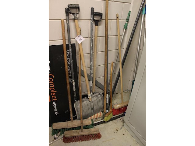 Handgereedschappen tegen de wand w.o. bezems, sneeuwscheppen, trekker etc. - afbeelding 2 van  2