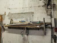 Handgereedschappen waaronder egaliseerblok, schrobber, trekker en stelen op schap. - afbeelding 1 van  3