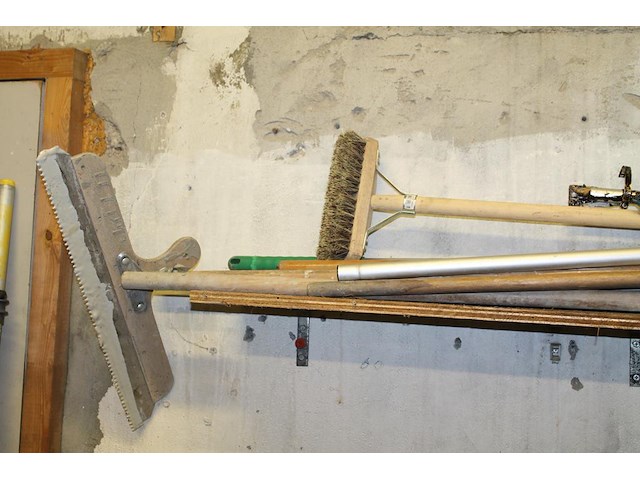 Handgereedschappen waaronder egaliseerblok, schrobber, trekker en stelen op schap. - afbeelding 3 van  3