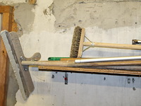 Handgereedschappen waaronder egaliseerblok, schrobber, trekker en stelen op schap. - afbeelding 3 van  3