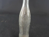 Historische coca-cola glazen fles met het iconische geribbelde 'hobbleskirt'-ontwerp, die sterk lijkt op de doorzichtige coca-cola flessen die tijdens de tweede wereldoorlog door amerikaanse soldaten werden gebruikt
