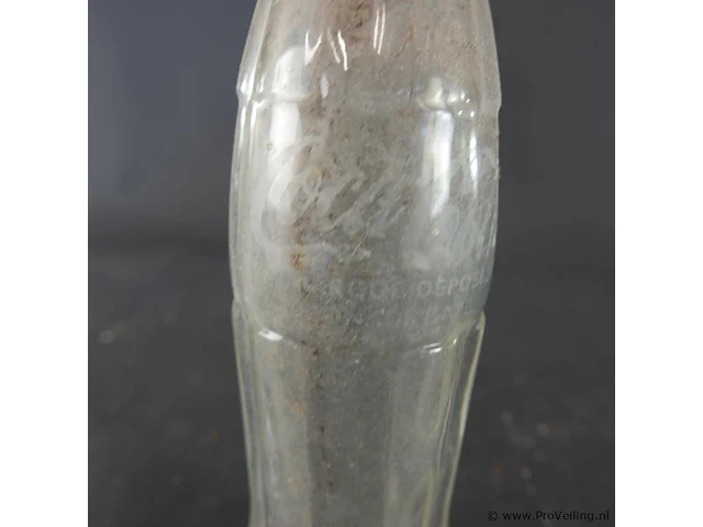 Historische coca-cola glazen fles met het iconische geribbelde 'hobbleskirt'-ontwerp, die sterk lijkt op de doorzichtige coca-cola flessen die tijdens de tweede wereldoorlog door amerikaanse soldaten werden gebruikt - afbeelding 2 van  6