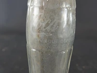 Historische coca-cola glazen fles met het iconische geribbelde 'hobbleskirt'-ontwerp, die sterk lijkt op de doorzichtige coca-cola flessen die tijdens de tweede wereldoorlog door amerikaanse soldaten werden gebruikt - afbeelding 2 van  6