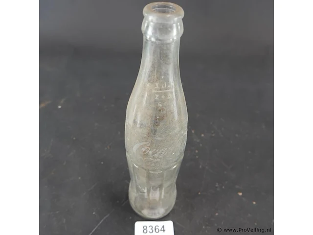 Historische coca-cola glazen fles met het iconische geribbelde 'hobbleskirt'-ontwerp, die sterk lijkt op de doorzichtige coca-cola flessen die tijdens de tweede wereldoorlog door amerikaanse soldaten werden gebruikt - afbeelding 3 van  6