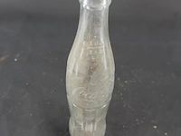 Historische coca-cola glazen fles met het iconische geribbelde 'hobbleskirt'-ontwerp, die sterk lijkt op de doorzichtige coca-cola flessen die tijdens de tweede wereldoorlog door amerikaanse soldaten werden gebruikt - afbeelding 3 van  6